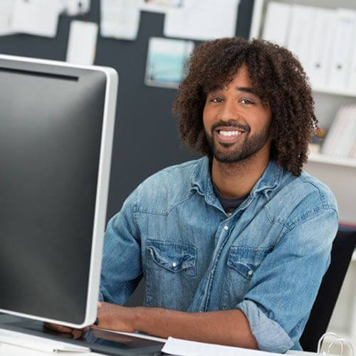 Smiling men working on the computer at the office