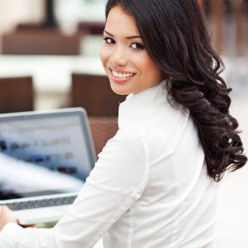 Cheerful woman posing for the photo sitting at the computer