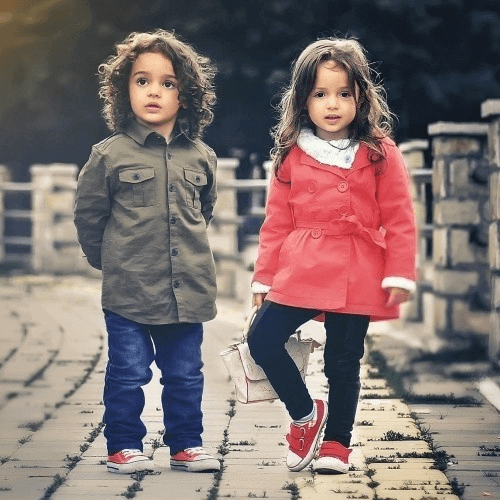 A little boy and girl stand posing for the photo