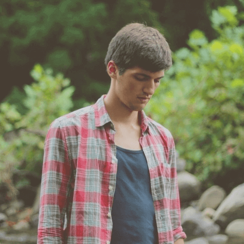 A young men looking down in the park