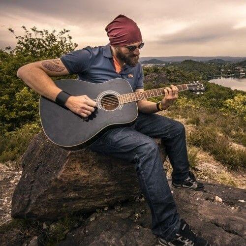 Men play guitar sitting on the rock