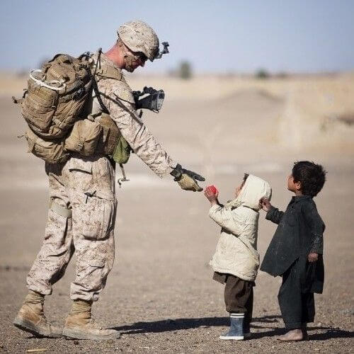 Soldier giving children an apple